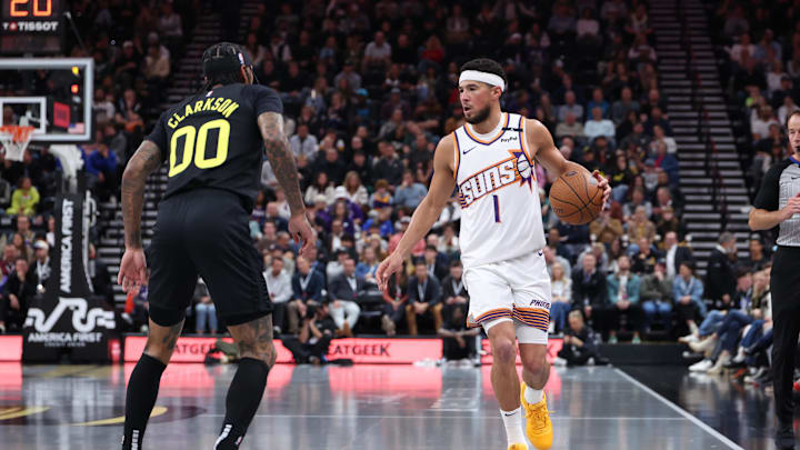Nov 12, 2024; Salt Lake City, Utah, USA; Phoenix Suns guard Devin Booker (1) brings the ball up the court against Utah Jazz guard Jordan Clarkson (00) during the second quarter at Delta Center. Mandatory Credit: Rob Gray-Imagn Images