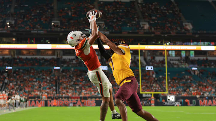 Sep 6, 2025; Miami Gardens, Florida, USA; Miami Hurricanes wide receiver CJ Daniels (7) catches the football for a touchdown against Bethune-Cookman Wildcats cornerback Gabe White (17) during the second quarter at Hard Rock Stadium. Mandatory Credit: Sam Navarro-Imagn Images