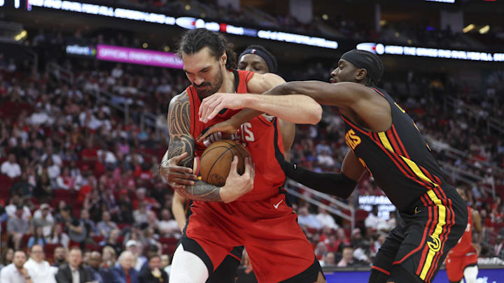 Mar 25, 2025; Houston, Texas, USA; Houston Rockets center Steven Adams (12) attempts to control the ball as Atlanta Hawks guard Caris LeVert (3) defends during the second quarter at Toyota Center. Mandatory Credit: Troy Taormina-Imagn Images