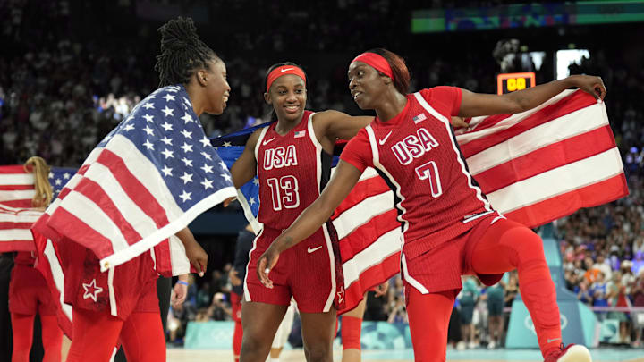 Aug 11, 2024; Paris, France; United States guard Chelsea Gray (8) and guard Jackie Young (13) and forward Kahleah Copper (7) celebrate after defeating France in the women's gold medal game during the Paris 2024 Olympic Summer Games at Accor Arena. Mandatory Credit: Kyle Terada-USA TODAY Sports