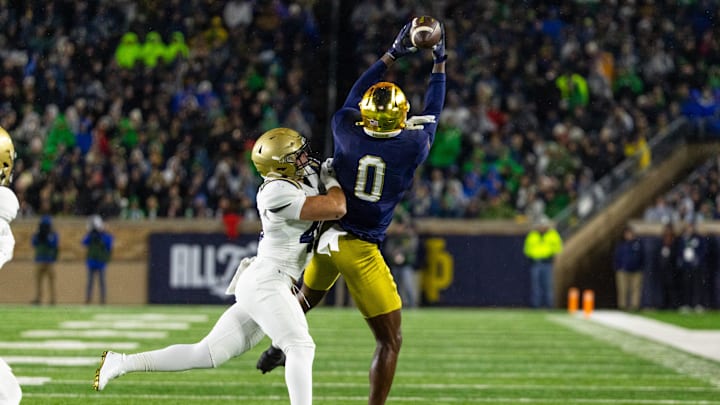 Nov 8, 2025; South Bend, Indiana, USA; Notre Dame Fighting Irish wide receiver Malachi Fields (0) makes a catch as Navy Midshipmen linebacker Adam Klenk (49) defends during the first half at Notre Dame Stadium.  