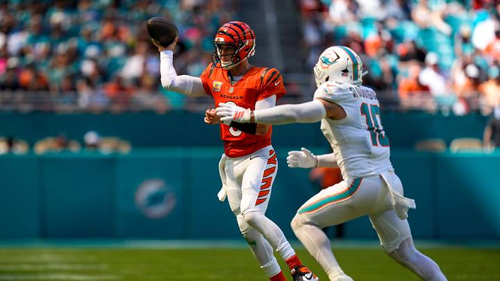 Cincinnati Bengals quarterback Joe Burrow (9) scrambles away from Miami Dolphins linebacker Jacob Rodriguez (10) in the second quarter of the NFL Week 5 game between the Miami Dolphins and the Cincinnati Bengals at Hard Rock Stadium in Miami Gardens, Florida, on Sunday, Oct. 11, 2026.
