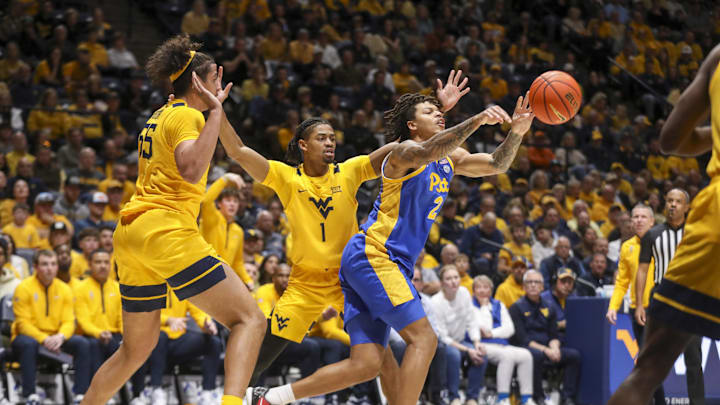 Nov 13, 2025; Morgantown, West Virginia, USA; Pittsburgh Panthers forward Cameron Corhen (2) passes between pressure from West Virginia Mountaineers center Harlan Obioha (55) and West Virginia Mountaineers guard Jasper Floyd (1) during the first half at WVU Coliseum. Mandatory Credit: Ben Queen-Imagn Images
