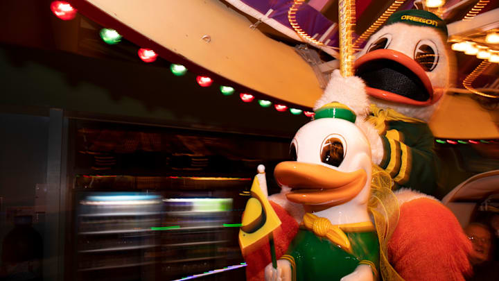 The real Oregon Duck mascot takes a ride on its carousel likeness.
