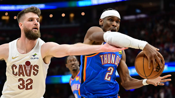 Jan 8, 2025; Cleveland, Ohio, USA; Oklahoma City Thunder guard Shai Gilgeous-Alexander (2) goes for a rebound against Cleveland Cavaliers forward Dean Wade (32) during the second half at Rocket Mortgage FieldHouse. Mandatory Credit: Ken Blaze-Imagn Images