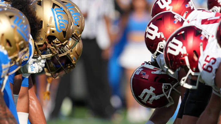 Sep 14, 2024; Pasadena, California, USA; UCLA Bruins and Indiana Hoosiers helmets at the line of scrimmage during the game at Rose Bowl. Mandatory Credit: Kirby Lee-Imagn Images