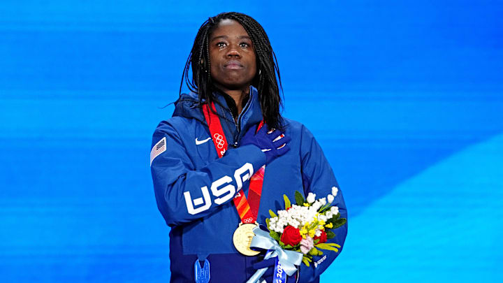 Erin Jackson (USA) celebrates winning the gold medal during the medals ceremony for the women's speed skating 500m at the Beijing 2022 Olympic Winter Games at Beijing Medals Plaza.