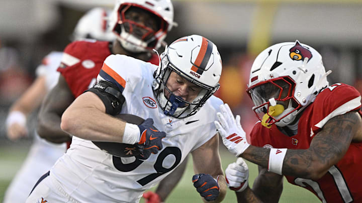 Oct 4, 2025; Louisville, Kentucky, USA; Virginia Cavaliers tight end John Rogers (89) runs the ball against Louisville Cardinals defensive back JoJo Evans Jr. (27) during the second half at L&N Federal Credit Union Stadium. Virginia defeated Louisville 30-27. Mandatory Credit: Jamie Rhodes-Imagn Images