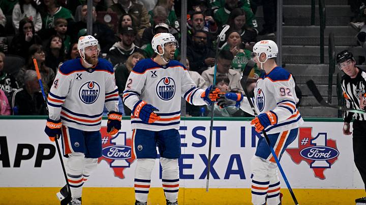 Mar 12, 2026; Dallas, Texas, USA; Edmonton Oilers defenseman Mattias Ekholm (14) and defenseman Evan Bouchard (2) and right wing Vasily Podkolzin (92) celebrates a goal scored by Bouchard against the Dallas Stars during the second period at the American Airlines Center. Mandatory Credit: Jerome Miron-Imagn Images