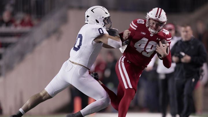 Oct 26, 2024; Madison, Wisconsin, USA; Wisconsin Badgers punter Atticus Bertrams runs for first down on a fake punt before being tackled by Penn State Nittany Lions linebacker Dominic DeLuca (0) during the first quarter at Camp Randall Stadium. Mandatory Credit: Mark Hoffman/USA TODAY Network via Imagn Images Oct 26, 2024; Madison, Wisconsin, USA; Wisconsin Badgers punter Atticus Bertrams runs for first down on a fake punt before being tackled by Penn State Nittany Lions linebacker Dominic DeLuca (0) during the first quarter at Camp Randall Stadium. Mandatory Credit: Mark Hoffman/USA TODAY Network via Imagn Images