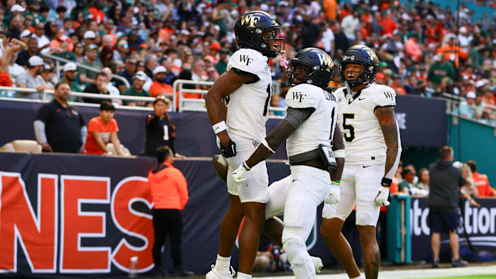Nov 23, 2024; Miami Gardens, Florida, USA; Wake Forest Demon Deacons wide receiver Micah Mays Jr. (18) celebrates with running back Demond Claiborne (1) after scoring a touchdown against the Miami Hurricanes during the first quarter at Hard Rock Stadium. Mandatory Credit: Sam Navarro-Imagn Images