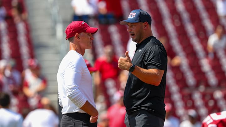 Oklahoma Sooners head coach Brent Venables (left) speaks with Tulane Green Wave head coach Jon Sumrall (right) before the game at Gaylord Family-Oklahoma Memorial Stadium