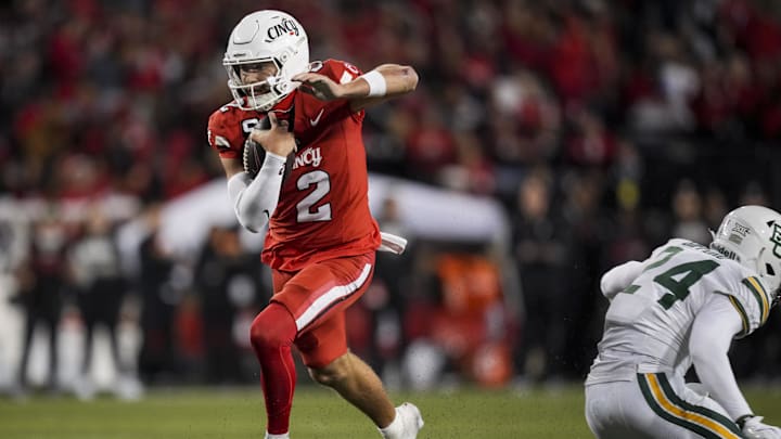 Oct 25, 2025; Cincinnati, Ohio, USA;  Cincinnati Bearcats quarterback Brendan Sorsby (2) avoids a tackle by Baylor Bears safety Micah Gifford (24) as he runs with the ball for a touchdown in the second half at Nippert Stadium. Mandatory Credit: Aaron Doster-Imagn Images