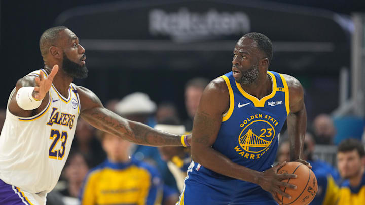 Dec 25, 2024; San Francisco, California, USA; Golden State Warriors forward Draymond Green (right) handles the ball against Los Angeles Lakers forward LeBron James (left) during the first quarter at Chase Center. Mandatory Credit: Darren Yamashita-Imagn Images