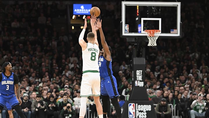 Jan 17, 2025; Boston, Massachusetts, USA; Boston Celtics center Kristaps Porzingis (8) shoots over Orlando Magic center Wendell Carter Jr. (34) during the first half at TD Garden. Mandatory Credit: Eric Canha-Imagn Images