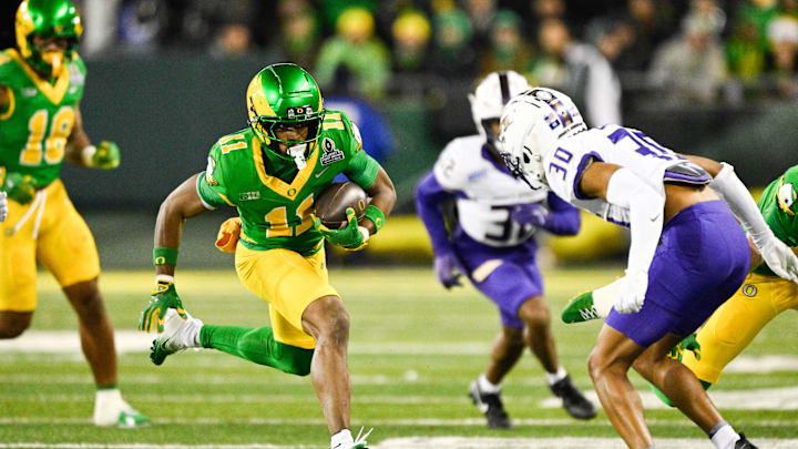 Dec 20, 2025; Eugene, OR, USA; Oregon Ducks wide receiver Jeremiah McClellan (11) runs after making a catch as James Madison Dukes cornerback Justin Eaglin (30) defends during the third quarter at Autzen Stadium. Mandatory Credit: Troy Wayrynen-Imagn Images
