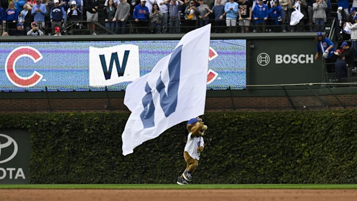 Sep 28, 2024; Chicago, Illinois, USA;  Clarke the Chicago Cubs mascot runs with the flag after a game against the Cincinnati Reds at Wrigley Field. Mandatory Credit: Matt Marton-Imagn Images