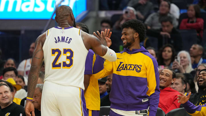 Dec 25, 2024; San Francisco, California, USA; Los Angeles Lakers forward LeBron James (23) slaps hands with guard Bronny James (center right) during the third quarter against the Golden State Warriors at Chase Center. Mandatory Credit: Darren Yamashita-Imagn Images
