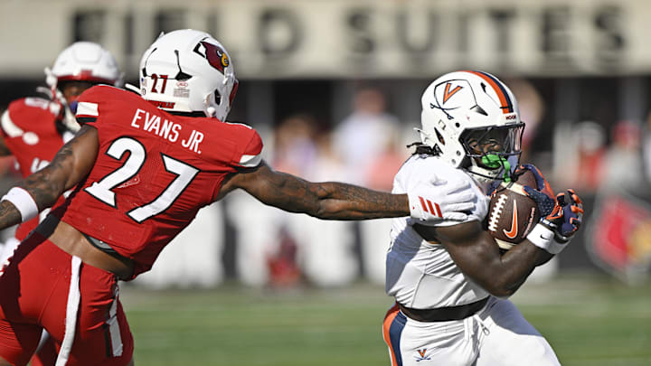 Oct 4, 2025; Louisville, Kentucky, USA; Virginia Cavaliers running back J'Mari Taylor (3) runs the ball past the reach of Louisville Cardinals defensive back JoJo Evans Jr. (27) during the second quarter at L&N Federal Credit Union Stadium. Mandatory Credit: Jamie Rhodes-Imagn Images