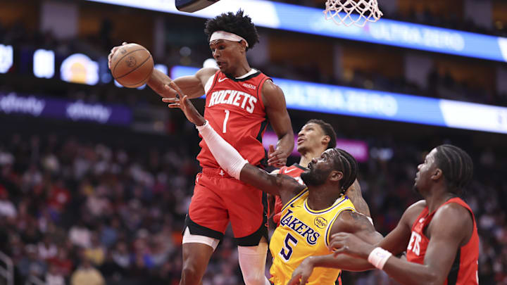 Mar 16, 2026; Houston, Texas, USA; Houston Rockets guard Amen Thompson (1) grabs a rebound away from Los Angeles Lakers center Deandre Ayton (5) during the third quarter at Toyota Center. Mandatory Credit: Troy Taormina-Imagn Images