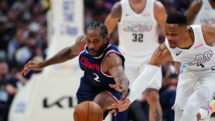 Apr 29, 2025; Denver, Colorado, USA; LA Clippers forward Kawhi Leonard (2) and Denver Nuggets guard Russell Westbrook (4) reach for a loose ball in the second half during game five of the first round for the 2025 NBA Playoffs at Ball Arena. Mandatory Credit: Ron Chenoy-Imagn Images