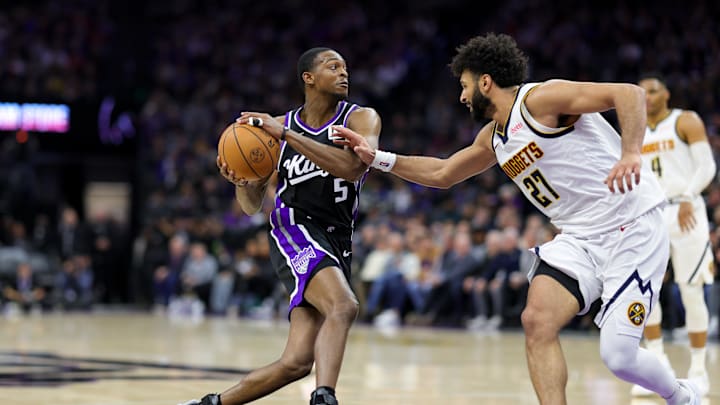 Dec 16, 2024; Sacramento, California, USA; Sacramento Kings guard De'Aaron Fox (5) controls the ball against Denver Nuggets guard Jamal Murray (27) during the third quarter at Golden 1 Center. Mandatory Credit: Sergio Estrada-Imagn Images