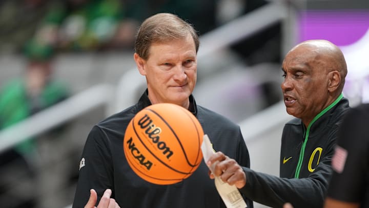Dec 21, 2024; San Jose, California, USA; Oregon Ducks head coach Dana Altman (center) tosses the game ball with assistant coach Tony Stubblefield (right) during the first half against the Stanford Cardinal at SAP Center at San Jose. Mandatory Credit: Darren Yamashita-Imagn Images