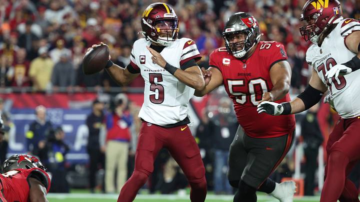 Jan 12, 2025; Tampa, Florida, USA; Washington Commanders quarterback Jayden Daniels (5) throws against Tampa Bay Buccaneers defensive tackle Vita Vea (50) during the first quarter of a NFC wild card playoff at Raymond James Stadium. Mandatory Credit: Kim Klement Neitzel-Imagn Images