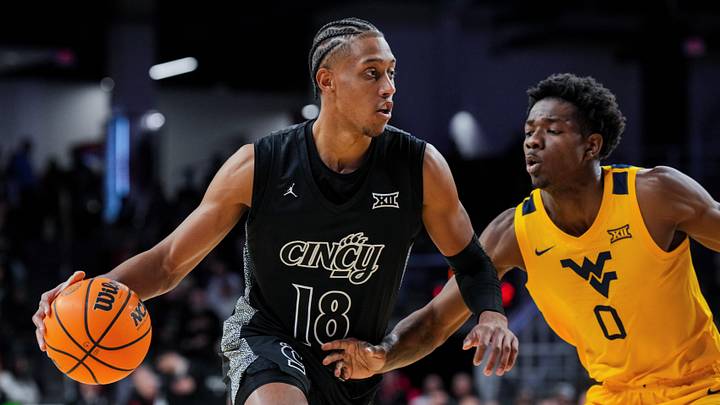 Feb 5, 2026; Cincinnati, Ohio, USA;  Cincinnati Bearcats forward Baba Miller (18) dribbles the ball against West Virginia Mountaineers forward Brenen Lorient (0) in the first half at Fifth Third Arena. Mandatory Credit: Aaron Doster-Imagn Images