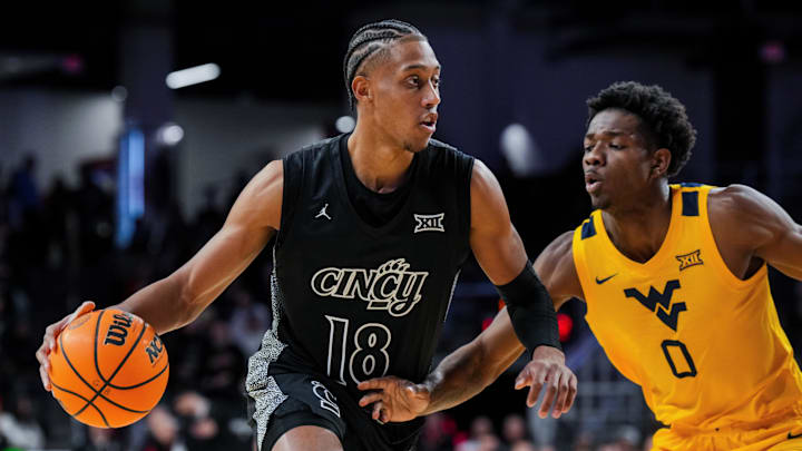 Feb 5, 2026; Cincinnati, Ohio, USA;  Cincinnati Bearcats forward Baba Miller (18) dribbles the ball against West Virginia Mountaineers forward Brenen Lorient (0) in the first half at Fifth Third Arena. Mandatory Credit: Aaron Doster-Imagn Images