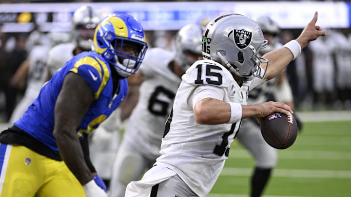 Las Vegas Raiders quarterback Gardner Minshew (15) points to throw the ball downfield with Los Angeles Rams linebacker Jared Verse (8) in pursuit in the second half at SoFi Stadium. 