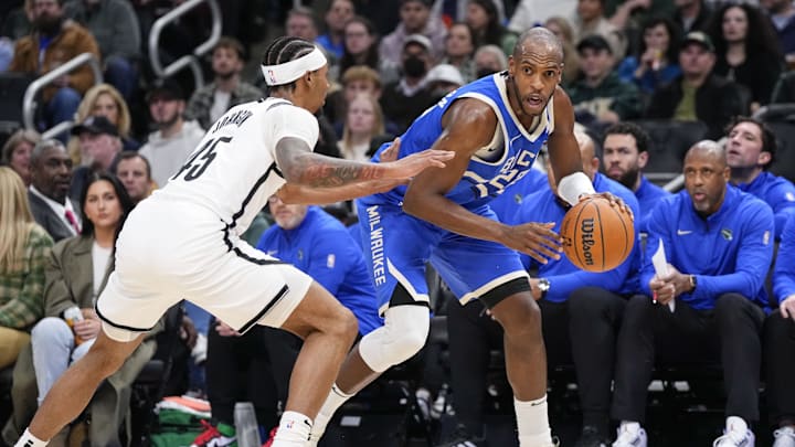 Dec 26, 2024; Milwaukee, Wisconsin, USA;  Milwaukee Bucks forward Khris Middleton (22) dribbles the ball under pressure from Brooklyn Nets guard Keon Johnson (45) during the first quarter at Fiserv Forum. Mandatory Credit: Jeff Hanisch-Imagn Images