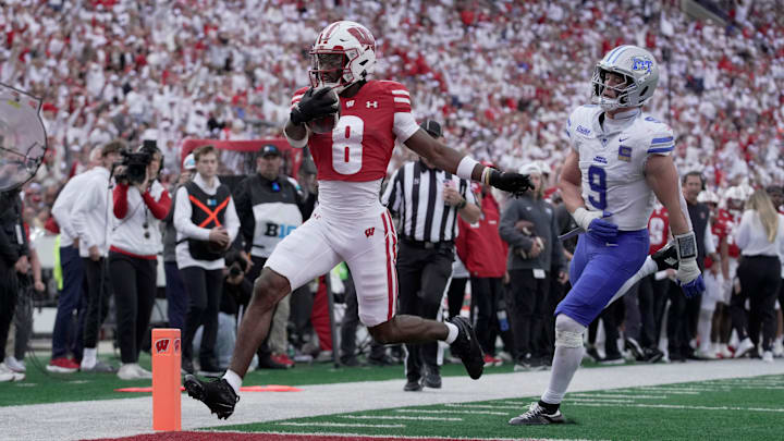 Wisconsin wide receiver Vinny Anthony II (8) scores a touchdown on a 14-yard run as Middle Tennessee linebacker Parker Hughes (9) looks on during the third quarter of the game Saturday, September 6, 2025 at Camp Randall Stadium in Madison, Wisconsin.