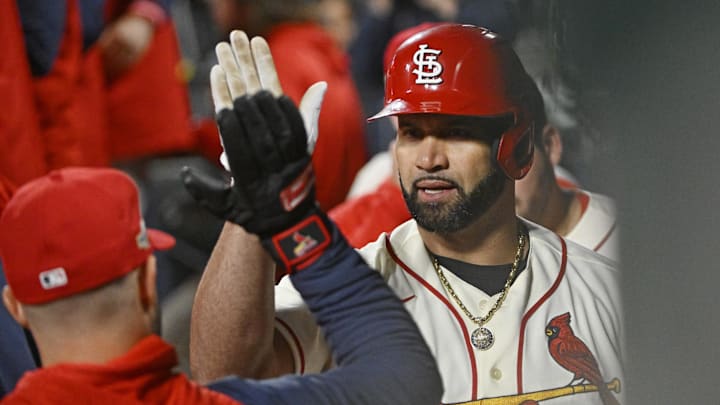 Oct 8, 2022; St. Louis, Missouri, USA; St. Louis Cardinals designated hitter Albert Pujols (5) is congratulated in the dugout following his single in the eighth inning against the Philadelphia Phillies during game two of the Wild Card series for the 2022 MLB Playoffs at Busch Stadium. 