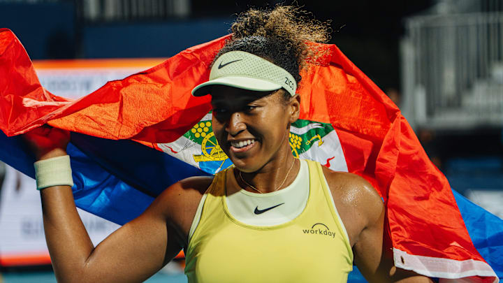 Naomi Osaka holds the Haitian flag after beating Liudmila Samsonova at the Miami Open.