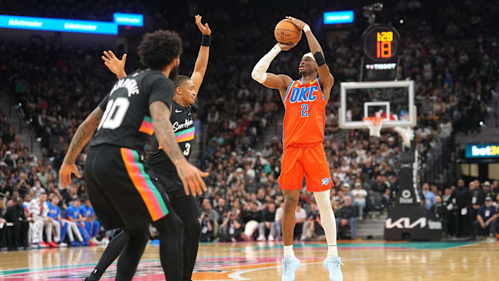 Dec 23, 2025; San Antonio, Texas, USA; Oklahoma City Thunder guard Shai Gilgeous-Alexander (2) shoots over San Antonio Spurs forward Keldon Johnson (3) during the second half at Frost Bank Center. Mandatory Credit: Scott Wachter-Imagn Images