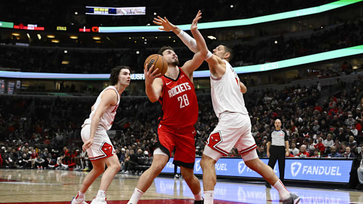 Nov 17, 2024; Chicago, Illinois, USA;  Houston Rockets center Alperen Sengun (28) drives to the basket against Chicago Bulls center Nikola Vucevic (9) and guard Josh Giddey (3) during the first half at United Center. Mandatory Credit: Matt Marton-Imagn Images
