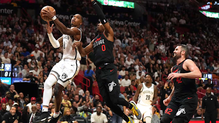 Nov 16, 2023; Miami, Florida, USA; Brooklyn Nets guard Lonnie Walker IV (8) goes up for a shot in the second half as Miami Heat guard Josh Richardson (0) and forward Kevin Love (42) defend at Kaseya Center. Mandatory Credit: Jim Rassol-Imagn Images