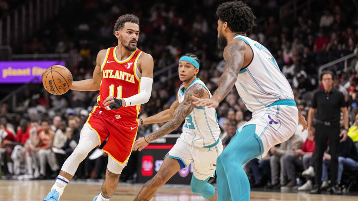 Apr 10, 2024; Atlanta, Georgia, USA; Atlanta Hawks guard Trae Young (11) controls the ball against Charlotte Hornets guard Tre Mann (23) during the first half at State Farm Arena. Mandatory Credit: Dale Zanine-USA TODAY Sports