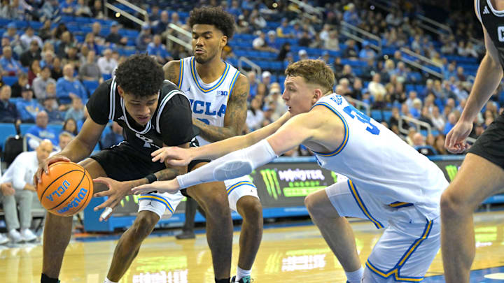 Dec 19, 2025; Los Angeles, California, USA; Cal Poly Mustangs guard Kieran Elliott (4) is defended by UCLA Bruins guard Donovan Dent (2) and forward Tyler Bilodeau (34) during the second half at Pauley Pavilion presented by Wescom Financial. Mandatory Credit: Jayne Kamin-Oncea-Imagn Images