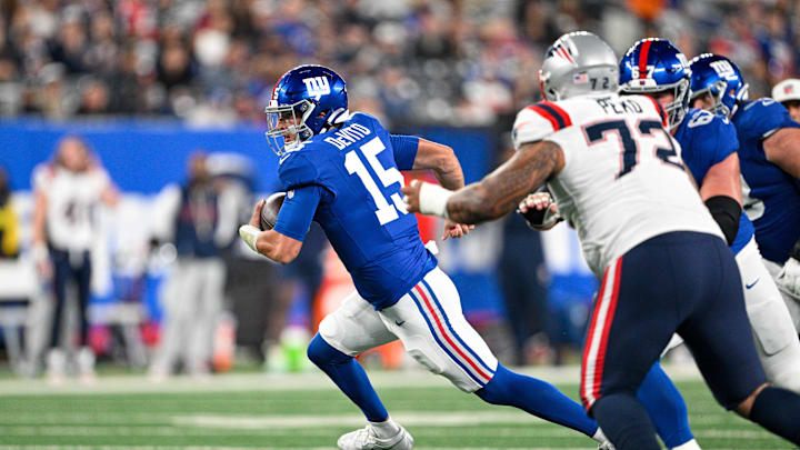 Aug 21, 2025; East Rutherford, New Jersey, USA; New York Giants quarterback Tommy DeVito (15) runs with the ball chased by New England Patriots defensive tackle Kyle Peko (72) during the third quarter  at MetLife Stadium. Mandatory Credit: Mark Smith-Imagn Images