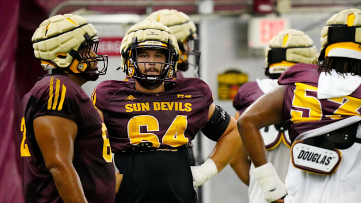 Arizona State offensive lineman Wade Helton (64) warms up with his teammates during a practice inside the Verde Dickey Dome in Tempe on Aug. 12, 2025. Arizona State offensive lineman Wade Helton (64) warms up with his teammates during a practice inside the Verde Dickey Dome in Tempe on Aug. 12, 2025.
