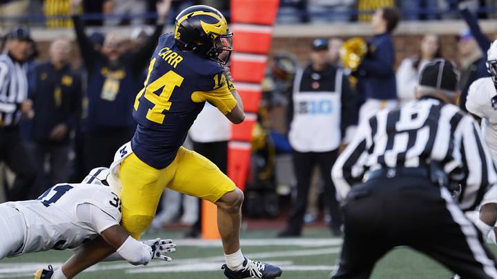Oct 17, 2026; Ann Arbor, Michigan, USA;  Michigan Wolverines quarterback Tommy Carr (14) runs the ball passed Penn State Nittany Lions defensive back Marcus Neal (31) in the second half at Michigan Stadium.  Mandatory Credit: Rick Osentoski-Imagn Images