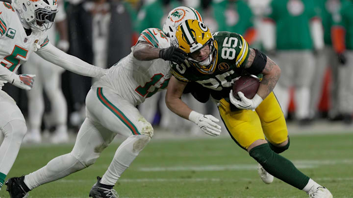 Green Bay Packers tight end Tucker Kraft (85) is tackled by Miami Dolphins linebacker Tyrel Dodson (11) after a short reception during the second quarter of their game Thursday, November 28, 2024 at Lambeau Field in Green Bay, Wisconsin.