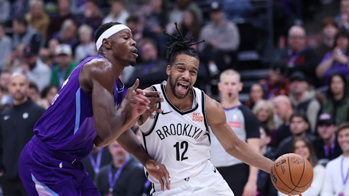 Jan 12, 2025; Salt Lake City, Utah, USA; Brooklyn Nets forward Tosan Evbuomwan (12) drives to the basket against Utah Jazz center Oscar Tshiebwe (34) during the second quarter at Delta Center. Mandatory Credit: Rob Gray-Imagn Images Jan 12, 2025; Salt Lake City, Utah, USA; Brooklyn Nets forward Tosan Evbuomwan (12) drives to the basket against Utah Jazz center Oscar Tshiebwe (34) during the second quarter at Delta Center. Mandatory Credit: Rob Gray-Imagn Images