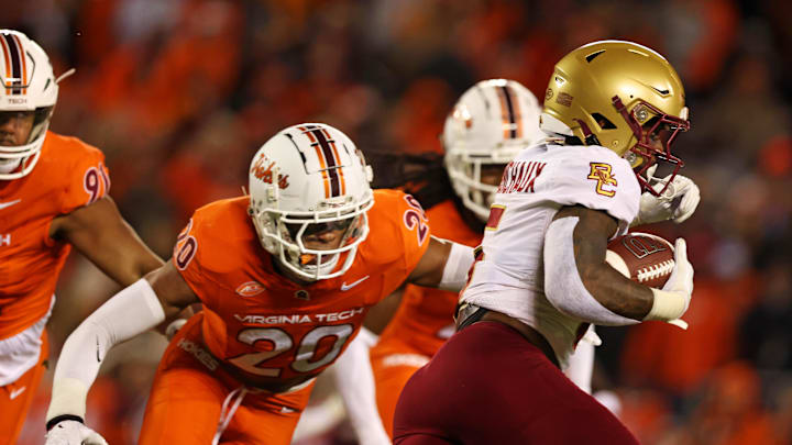 Oct 17, 2024; Blacksburg, Virginia, USA; Boston College Eagles running back Kye Robichaux (5) runs the ball against Virginia Tech Hokies defensive lineman Josh Fuga (6) during the first quarter at Lane Stadium. Mandatory Credit: Peter Casey-Imagn Images