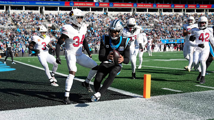 Dec 22, 2024; Charlotte, North Carolina, USA;  Carolina Panthers quarterback Bryce Young (9) scores a touchdown as Arizona Cardinals safety Jalen Thompson (34) defends in the second quarter at Bank of America Stadium. Mandatory Credit: Bob Donnan-Imagn Images