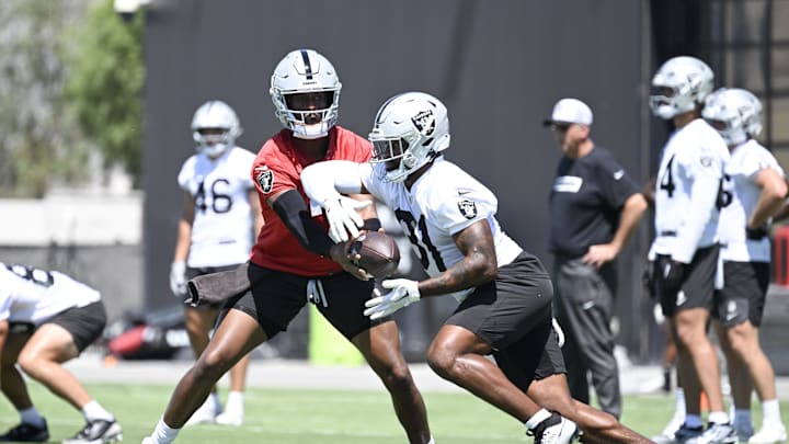 Jun 10, 2025; Henderson, NV, USA; Las Vegas Raiders quarterback Geno Smith (7) hands the ball off to running back Raheem Mostert (31) during a drill at Las Vegas Raiders Minicamp at Intermountain Health Performance Center. Mandatory Credit: Candice Ward-Imagn Images Jun 10, 2025; Henderson, NV, USA; Las Vegas Raiders quarterback Geno Smith (7) hands the ball off to running back Raheem Mostert (31) during a drill at Las Vegas Raiders Minicamp at Intermountain Health Performance Center. Mandatory Credit: Candice Ward-Imagn Images