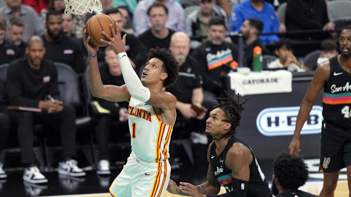Nov 20, 2025; San Antonio, Texas, USA; Atlanta Hawks forward Jalen Johnson (1) drives to the basket past San Antonio Spurs guard Devin Vassell (24) during the second half at Frost Bank Center. Mandatory Credit: Scott Wachter-Imagn Images