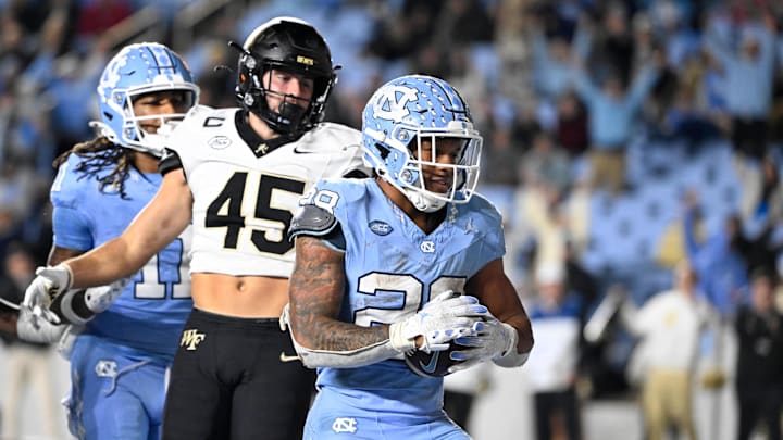 Nov 16, 2024; Chapel Hill, North Carolina, USA; North Carolina Tar Heels running back Omarion Hampton (28) scores a touchdown as Wake Forest Demon Deacons defensive back Nick Andersen (45) defends in the fourth quarter at Kenan Memorial Stadium. 